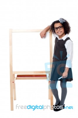 Cute School Kid Posing With Hand On Whiteboard Stock Photo