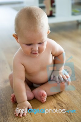 Cute Smiling Baby Sitting At Home Stock Photo