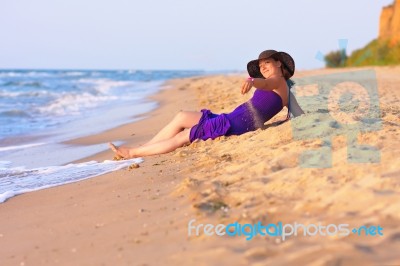 Cute White Girl Laying On Sand At The Beach Stock Photo