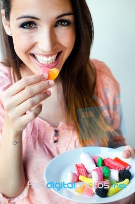 Cute Young Woman Eating Jelly Candies With A Fresh Smile Stock Photo