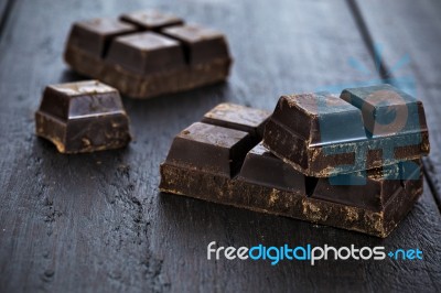Dark Chocolate Pieces On Wooden Table Background Stock Photo