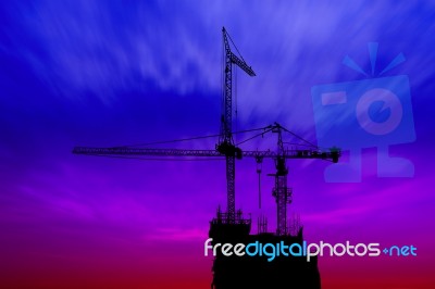 Dark Twilight And Silhouette Construction With Crane On Top Building Stock Photo