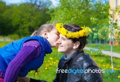 Daughter Kisses Mom In The Park Stock Photo