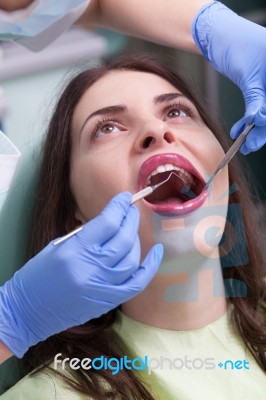 Dentist Curing A Female Patient Stock Photo