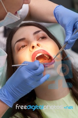 Dentist Curing A Female Patient Stock Photo