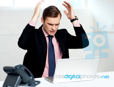 Disappointed Businessman Looking At Laptop Stock Photo