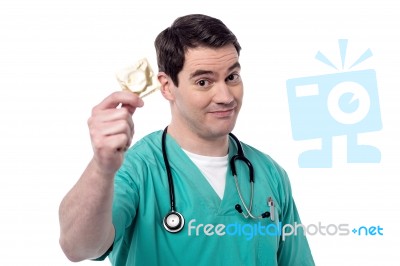 Doctor Holding Condom Over White Stock Photo