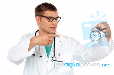 Doctor Pointing At Alarm Clock Stock Photo