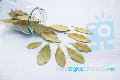 Dried Bay Leaves In Glass Jar On White Wooden Background Stock Photo