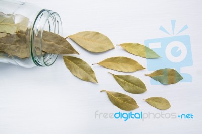 Dried Bay Leaves In Glass Jar On White Wooden Background Stock Photo