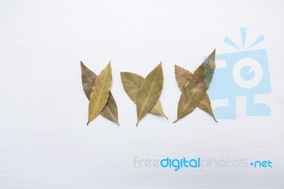 Dried Bay Leaves On White Wooden Background Stock Photo