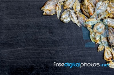 Dry Fish With Sunny On Black Wooden Floor Stock Photo
