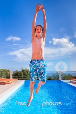 Dutch Teenage Boy Jumping High Above Blue Swimming Pool Stock Photo