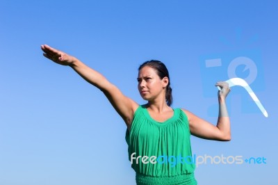 Dutch Woman Throwing Boomerang In Blue Sky Stock Photo