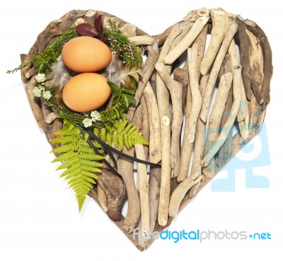 Easter Nest With Twio Eggs And Feathers On Sweet-heart Stock Photo