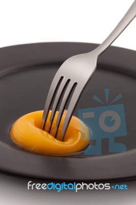 Egg Yolk With Fork Pricking Stock Photo