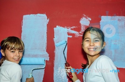 Eight Year Old Twins Girls Painting The Wall At Home Stock Photo