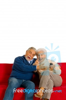 Elderly Couple With Remote Control Stock Photo