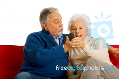 Elderly Couple With Remote Control Stock Photo