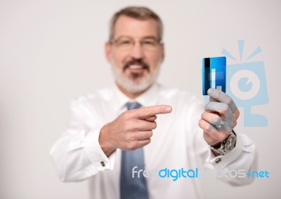 Elderly Man Focusing On Debit Card Stock Photo