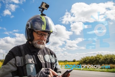Elderly Man Motorcyclist In Protective Helmet Looking At Smartph… Stock Photo