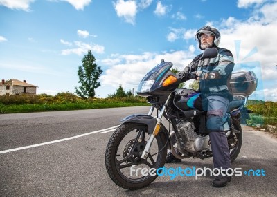 Elderly Motorcyclist Wearing A Jacket And Glasses With A Helmet Stock Photo