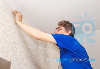 Elderly Worker Attaching Wallpaper Stock Photo