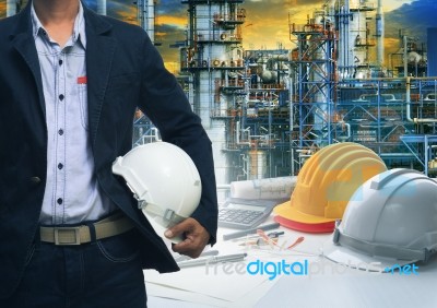 Engineering Man Standing With White Safety Helmet Against  Oil R… Stock Photo