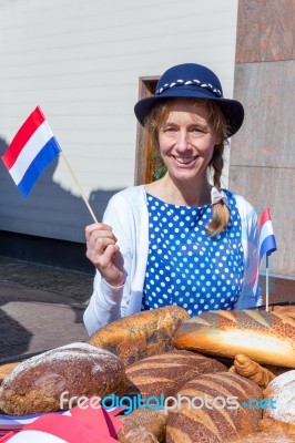 European Woman With Breads Waving With Dutch Flag Stock Photo