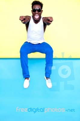 Excited Male Jumping And Pointing Stock Photo