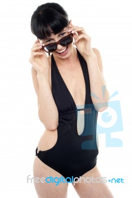 Exotic Woman In Black Bikini Peeking Through Her Sunglasses Stock Photo