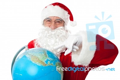 Expressionistic Santa Pointing At North Pole On Globe Stock Photo