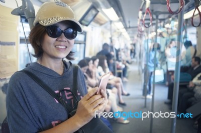 Face Of Woman In Sky Train With Smart Phone In Hand Stock Photo