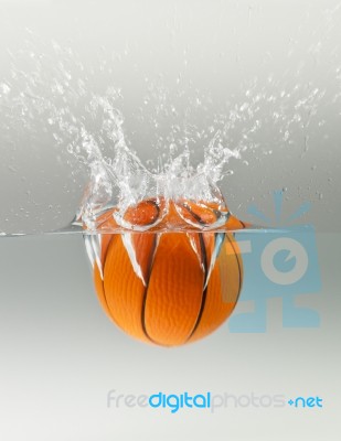 Falling Basketball Into Water Stock Photo
