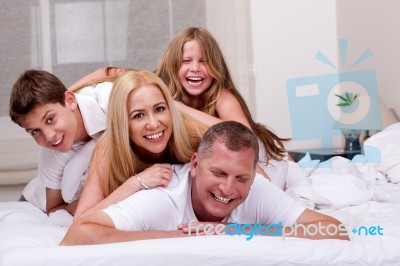 Family Having Fun In Bed Stock Photo