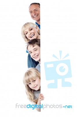 Family Of Four Behind Blank Whiteboard Stock Photo