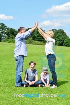 Family Of Four Is Having Fun In The Park Stock Photo