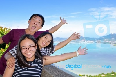 Family Of Tourists Inviting To See The Sea In Phuket, Thailand Stock Photo