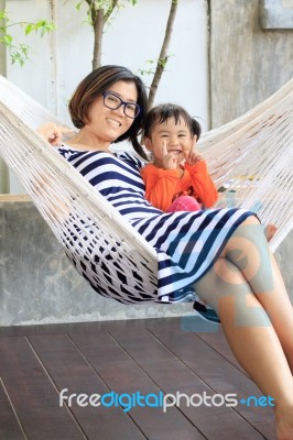 Family Relaxing Time Mother And Young Kid On White Clothes Cradl… Stock Photo