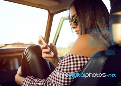 Fashion Beautiful Girl Using Her Mobile Phone In The Car Stock Photo
