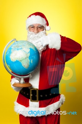 Father Christmas Showing His Country On Globe Stock Photo
