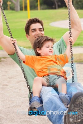 Father Enjoying Swing Ride With His Son Stock Photo