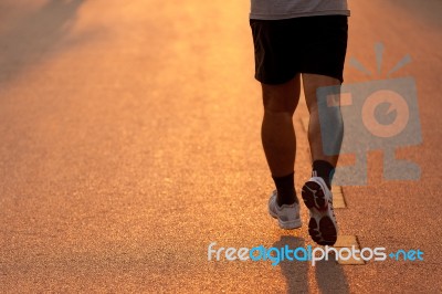 Feet Of Runner In Evening Light Stock Photo