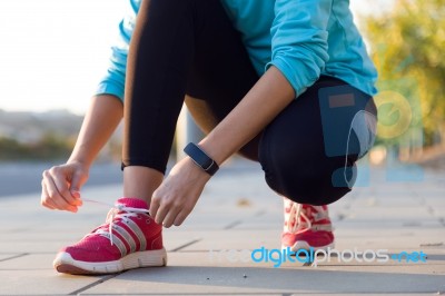 Female Athlete Tying Laces For Jogging Stock Photo