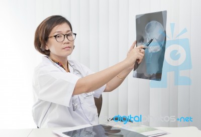 Female Doctor Pointing To X-ray Film Of Head Gull Stock Photo