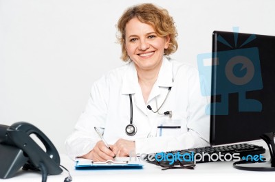 Female Doctor Writing On Clipboard Stock Photo