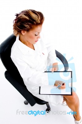Female Doctor Writing On Notepad Stock Photo