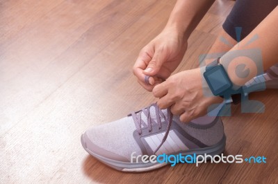 Female Hand Tying Shoelaces Wearing Watchband Smartwatch Stock Photo