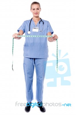 Female Physician Holding Measuring Tape Stock Photo