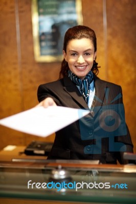 Female Receptionist Giving Paper Stock Photo